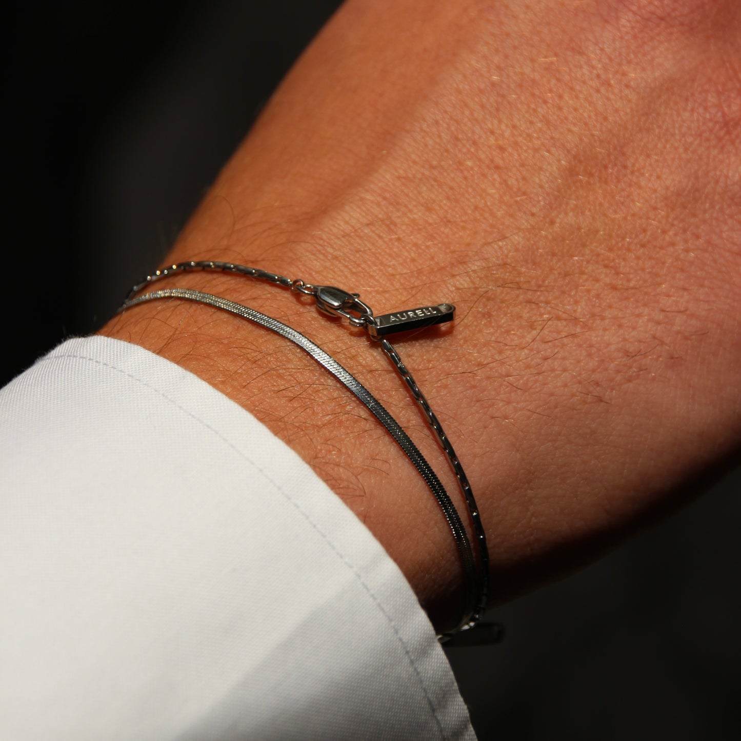 Edelstahl Armband, geflochten mit AURELL Logo an Handgelenk Herren