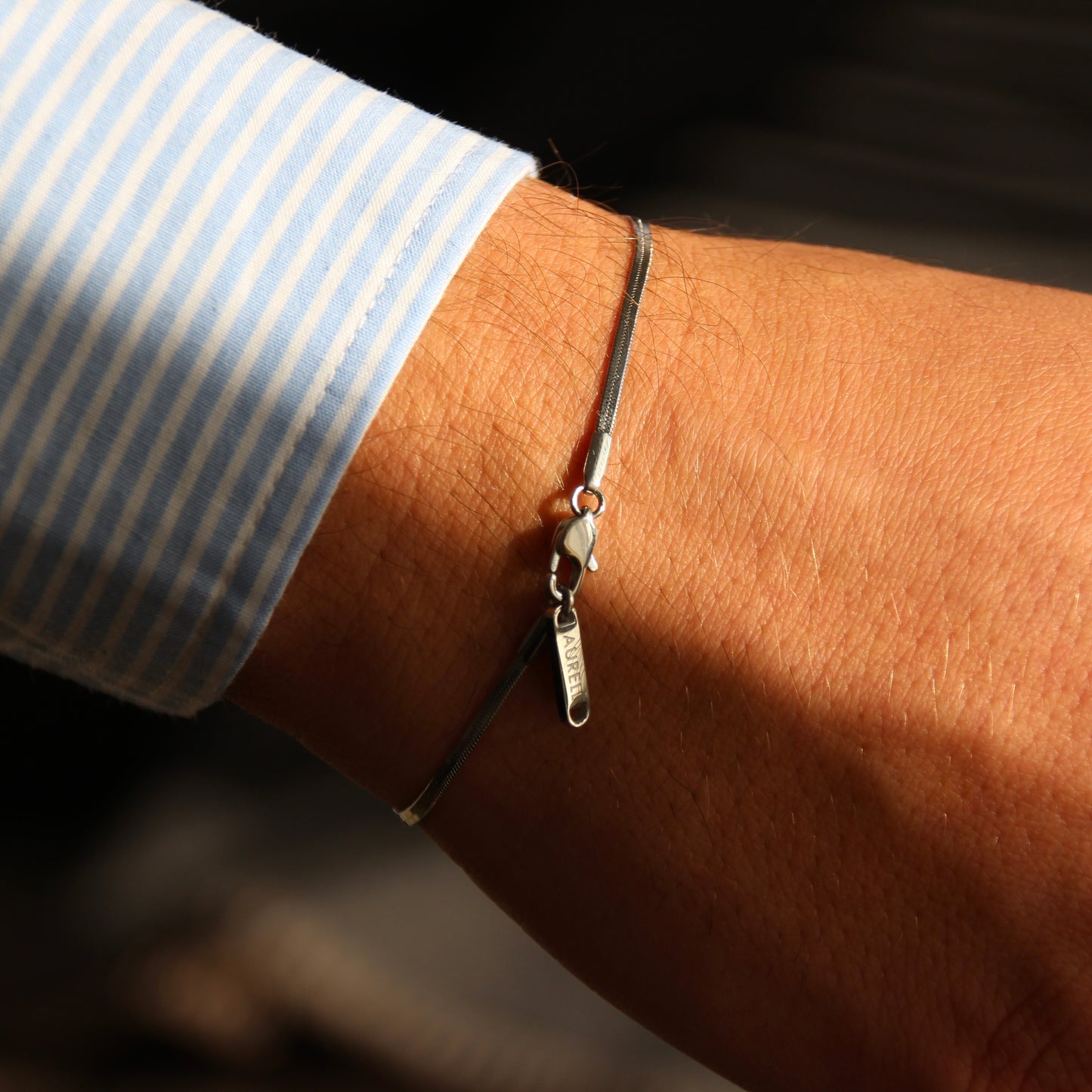 Edelstahl Armband, geflochten mit AURELL Logo an Handgelenk Herren