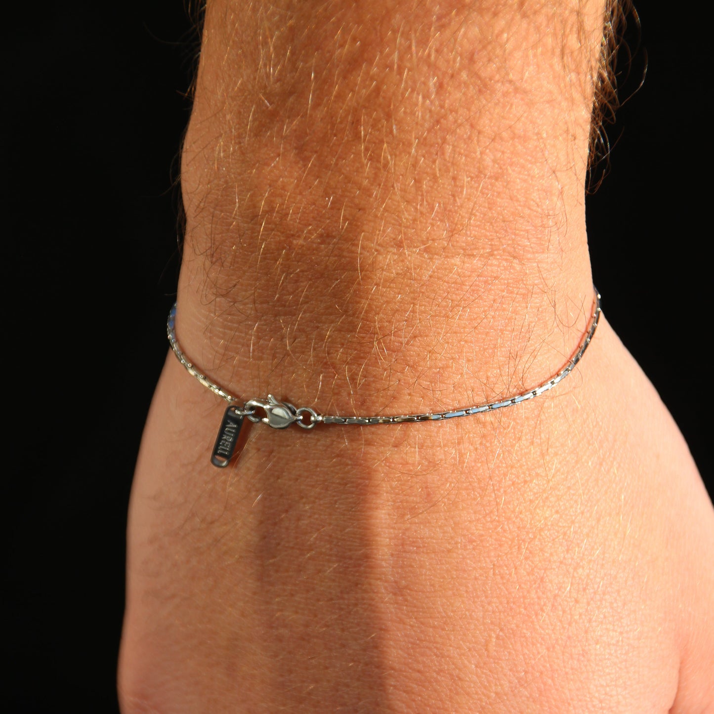 Edelstahl Armband, geflochten mit AURELL Logo an Handgelenk Herren