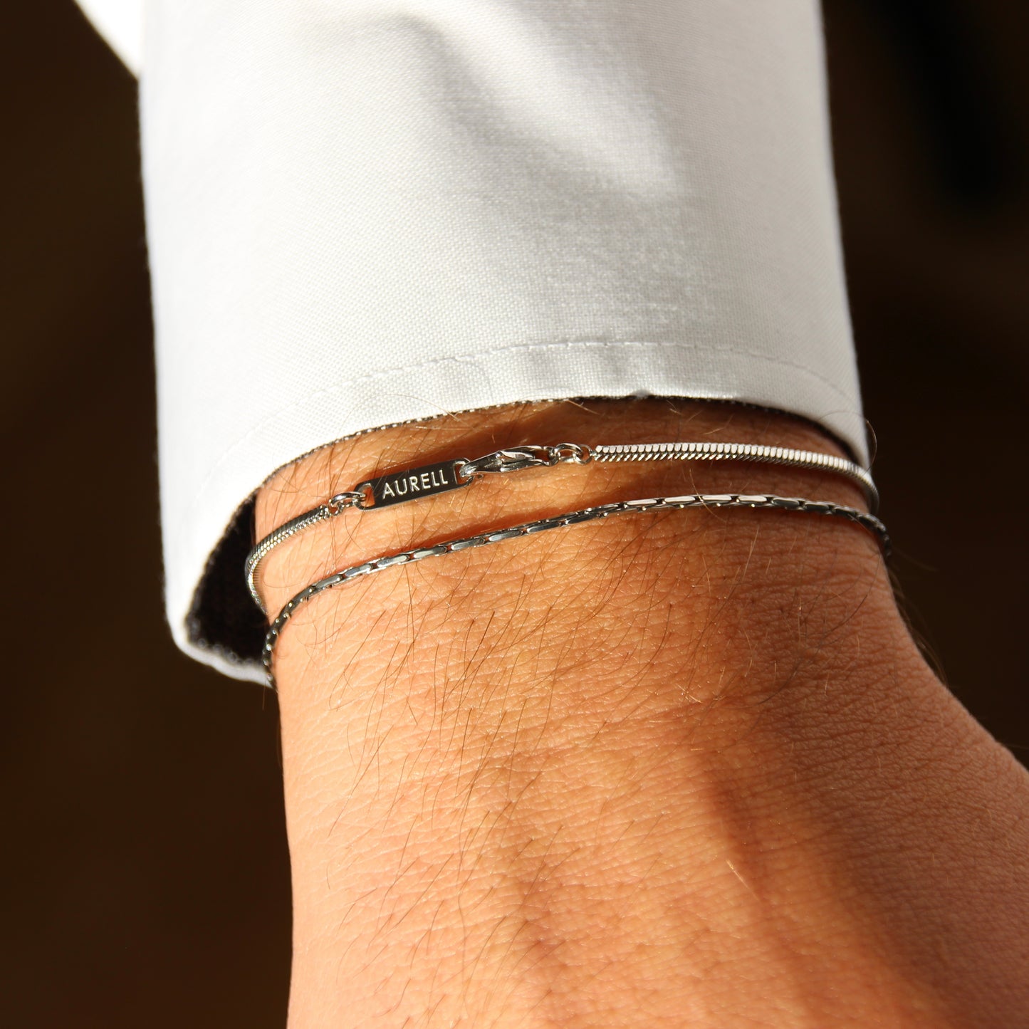 Edelstahl Armband, geflochten mit AURELL Logo an Handgelenk Herren