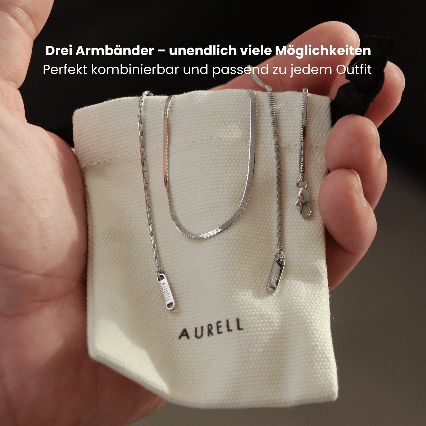 Edelstahl Armband, geflochten mit AURELL Logo in Herrenhand auf Stoffbeutel